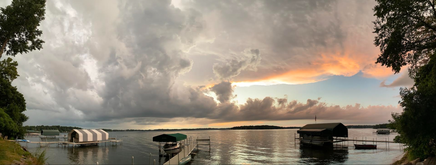 minnesota lake thunderstorm and sunset with docks and boats